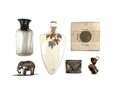 A collection of small items. To include an Edwardian silver envelope stamp holder, Birmingham 1902, a gilded charm in the for