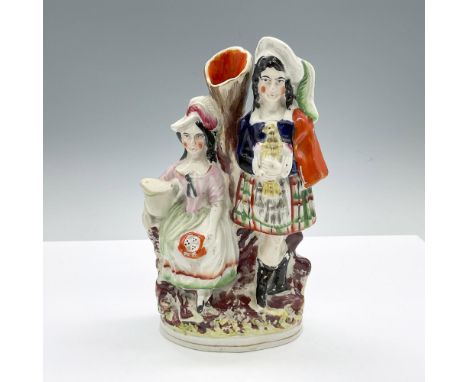 Hand made and hand painted figural vase featuring a couple. The woman is seated with a pitcher of milk, and the man is standi
