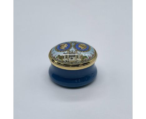 This miniature blue box showcases images of Charles and Camila's profiles with golden accents and a screw on lid. This item h