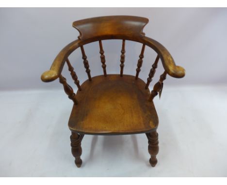 An oak smoker's bow armchair with spindle back