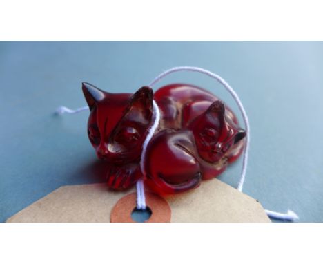 A Japanese amber netsuke in the form of cat with a kitten, signed to the base, W 5.5cm 