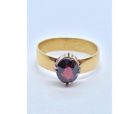 22 ct  Gold Band RING with an Oval Garnet Centre Stone.  4.9g  Size R. 