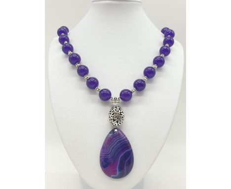 A Tibetan silver with purple jade and agate necklace in a presentation box. Colour enhanced. Necklace length: 48cm.