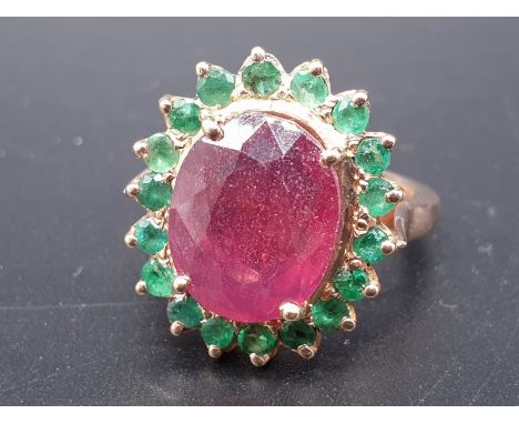 A 9ct Ruby ring with a halo of emerald accents in 925 silver gold plating, weight 8g and size M1/2 