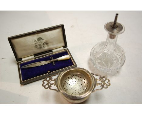 An early 20th century cut glass silver mounted Angostura Bitters decanter, together with silver tea strainer on stand, and si