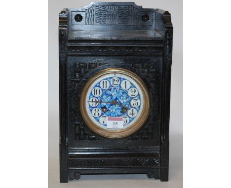 An Aesthetic Movement mantel clock, having an ebonised case, painted porcelain dial with Arabic numerals, and eight day movem