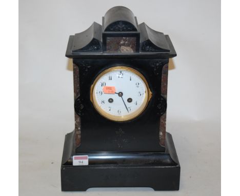 A late Victorian black slate mantel clock, of architectural form, having an enamel dial with Arabic numerals, and eight day m