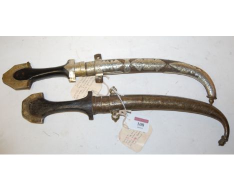 A 19th century jambiya, having curved steel blade and ebonised handle within white metal overlaid scabbard; together with one
