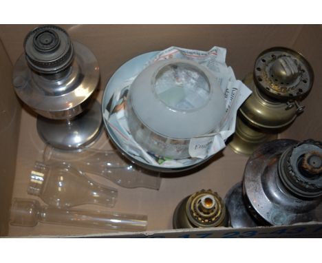 An early 20th century brass pedestal oil lamp, having iridescent globular shade; together with three other oil lamps, and one