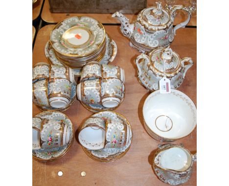 An early 19th century English porcelain part tea service, decorated with floral sprays on a grey ground, within gilt borders 