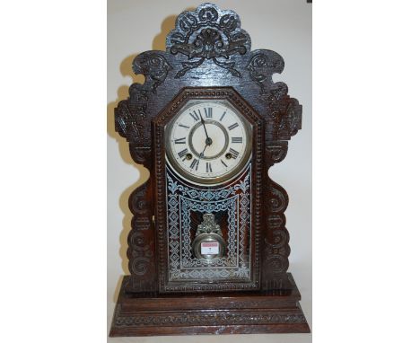 A late 19th century continental oak cased mantel clock, having paper dial and eight day movement striking on a gong 