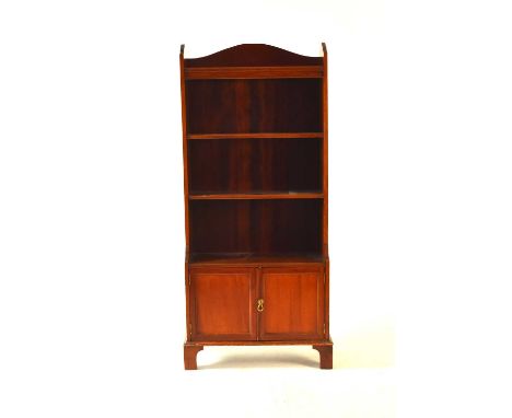 An Edwardian mahogany open bookcase, four—tiers above a pair of small panelled doors, raised on bracket feet, 62cm wide x 28c