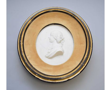 A carved white marble cameo portrait of a young woman, late 19th century, of oval aspect, the figure facing sinister, her hai