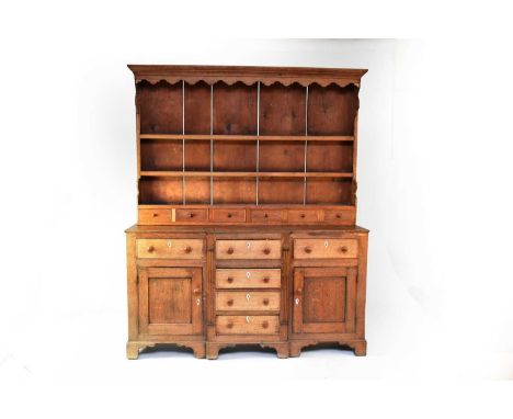 A 19th century oak break-front dresser and associated rack, the ogee frieze above a boarded delft rack with two shelves and s