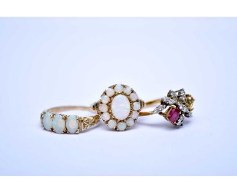 A 9ct gold opal cluster ring, size N, together with a 9ct gold three stone opal ring, size M 1/2 and a diamond and ruby clust