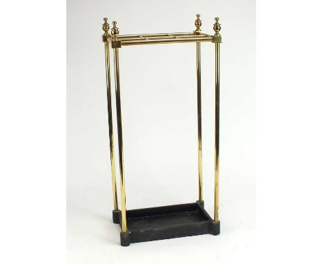 An Edwardian brass stick stand, the grid top with four vase finials, set on a cast iron tray base, 30cm wide x 19cm deep x 64