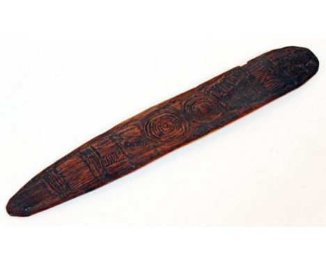 An Aboriginal shield of typical form with carved geometric patterns, length 39cm.