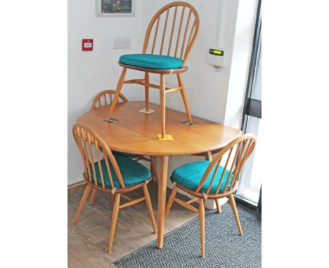 An Ercol light elm and beech drop leaf table and four chairs.