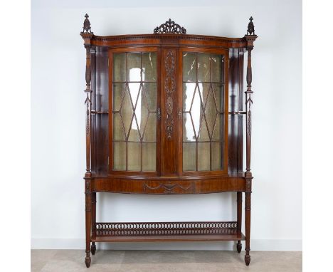 An Edwardian mahogany bow fronted Sheriton&nbsp; Revival astragal glazed display cabinet with open fretwork finial doors flan