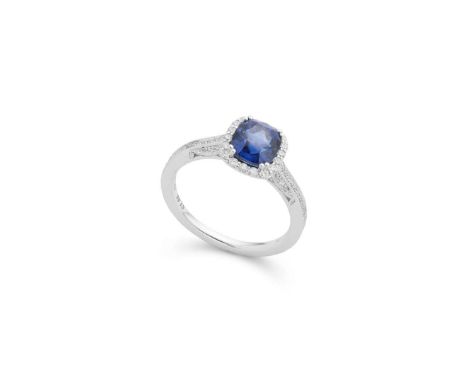  A sapphire and diamond cluster ring  Claw-set with a cushion-cut sapphire in a border of round brilliant-cut diamonds, the g