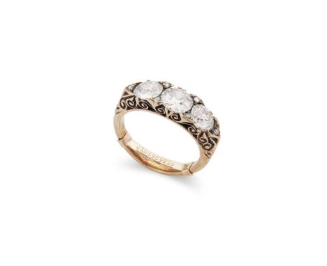  A diamond three-stone ring  Claw-set with three graduated old round-cut diamonds, diamond chip-detail, scrolling detail to g