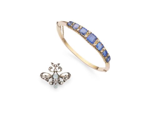  An early 20th century aquamarine and diamond brooch  Of open scrolling form, set throughout with small round-cut diamonds an