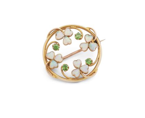  An early 20th century opal and garnet brooch  Of circular outline with floral detail, set with cabochon opals and round-cut 