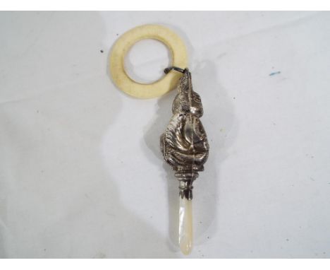 A hallmarked silver and mother of pearl baby's rattle in the form of a rabbit, Birmingham assay (date mark unclear). Est £40 