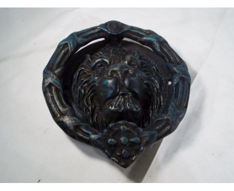 A large cast iron door knocker in the form of a lions head, 25cm x 22cm Est £20 - £40 - This lot MUST be paid for and collect