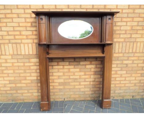 A mahogany fire surround with over-mantel bevel-edged oval mirror, 180 cm (h) x 145 cm (w) - width of opening 100 cm - This l
