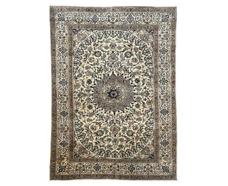 Persian Kashan ivory ground carpet, central rosette medallion surrounded by swirling leafy branches and floral sprays, the ma