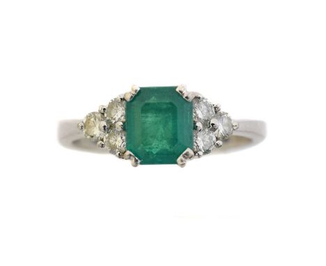 An 18ct gold emerald and diamond dress ring.  The rectangular shape emerald weighing approx. 0.80ct with brilliant cut diamon