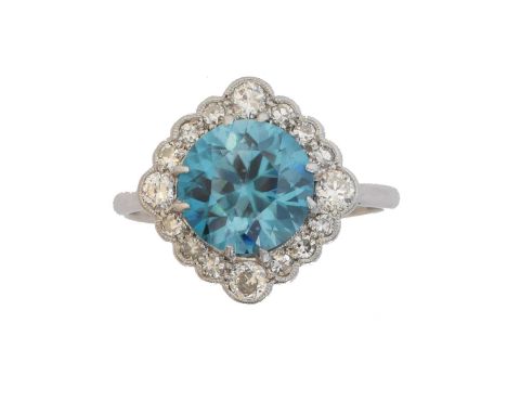 A zircon and diamond cluster ring.  The circular shape zircon within a brilliant and single cut diamond scalloped surround, e