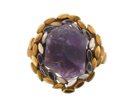 A 1960s 18ct gold amethyst dress ring by John Donald.  Of bi-colour design, the amethyst crystal within a grooved and marquis