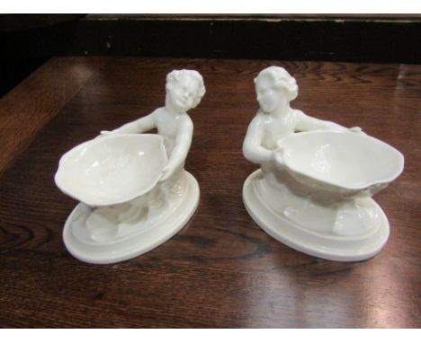 A pair of white Royal Worcester salt dishes in the form of mermaids holding a shell, 10cm x 14cm 