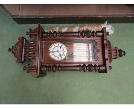 An early 20th Century Vienna wall clock with turned detail and Roman numerated dial 