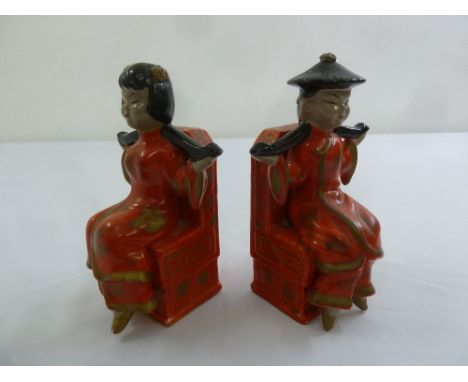 A pair of Oriental ceramic bookends in the form of seated figures