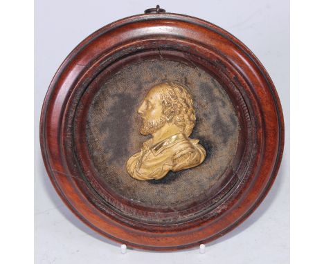 A 19th century gilt-metal portrait plaque, of William Shakespeare, bust-length and in profile, turned mahogany circular frame