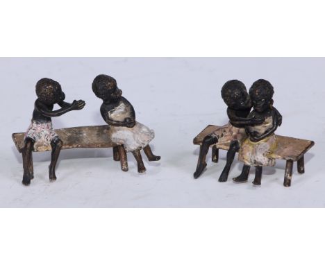 A pair of Austrian cold painted bronzes, of a young black boy and his reluctant sweetheart, seated on a bench, 6cm and 4.5cm 