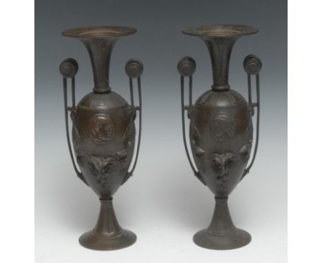 A pair of 19th century Grecian Revival brown patinated bronze vases, each cast with portrait ovals and flanked by volutes, 23