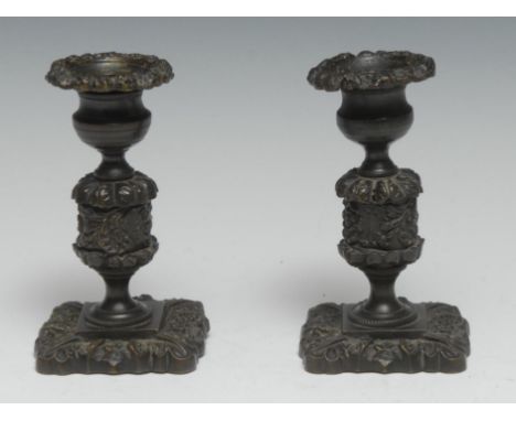 A pair of Regency dark patinated bronze candlesticks, cast with flowers and acanthus, shaped square bases, 12cm high, c.1820 