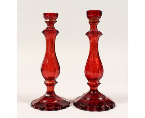 A PAIR OF RUBY GLASS CANDLESTICKS 8.5ins high