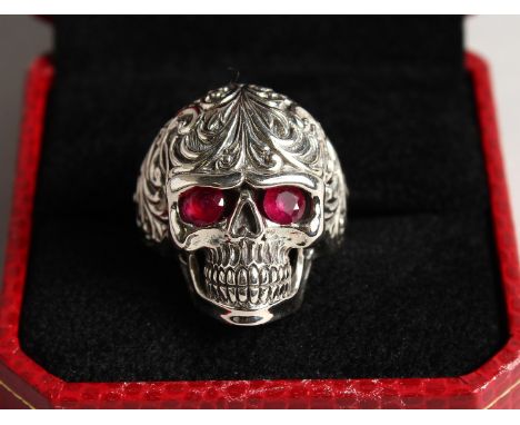 A SILVER SKULL RING with ruby eyes