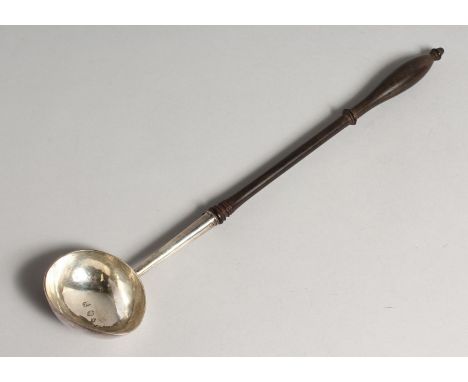 A GEORGE II PUNCH LADLE with plain bow and turned wood handle 14ins long London 1728 maker J.C..