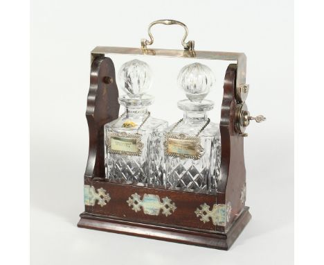 A TWO BOTTLED WHISKY DECANTER AND STOPPERS in a tantalus.