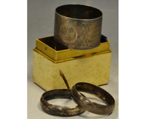 A silver engine turned napkin ring; a pair of silver napkin rings , 25.9g gross