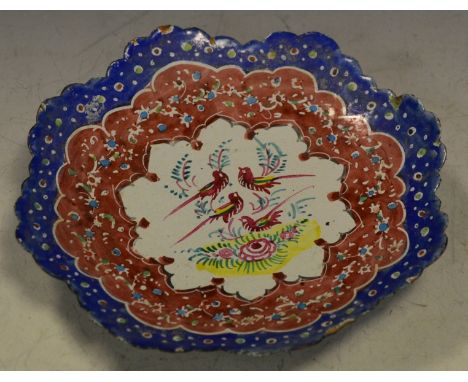 A Persian enamel sweetmeat dish , fluted octagonal edge , central cartouche painted with fanciful Birds