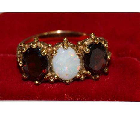 An opal and garnet three stone ring