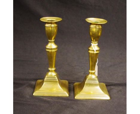 Pair antique brass candlesticks each with decorated columns to square stepped bases, candle ejector mechanism to 1 candlestic