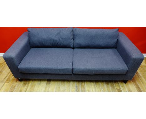 A contemporary three seater sofa upholstered in a grey wool fabric, raised on squared tapering supports